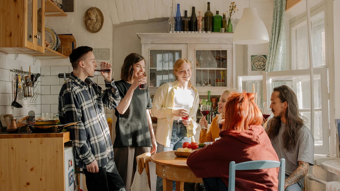 Un gruppo di giovani seduti insieme in cucina 